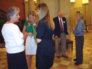 Photo of people holding red tulips at SC State House and waiting for ceremony to start